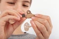 Close up of a young boy`s hands replacing a battery of a hearing aid with open batter compartment